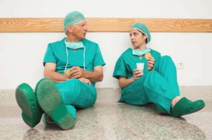 Surgeons sitting against wall